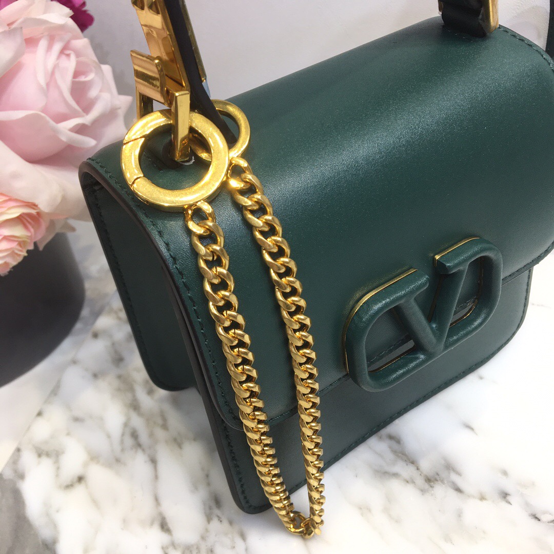 VALENTINO VSling Mini Shoulder bag - CRIS&COCO VALENTINO VSling Mini Leather Shoulder Bag. Authentic Quality Bag with literature, gift box, dust bag and authenticity card. The label's new V Ring logo, we've got to admit that we were like 'Rockstuds who? Pierpaolo Picciolil employs clean lines and considered details for Valentino's SS20 accessories offering and this orange leather V-logo bag is the elegant result. It's crafted with an adjustable cross-body strap and the namesake logo plaque across the front flap, then opens to reveal a black leather interior with a single slip pocket. Style it over the body of a blouse tucked into a midi skirt. | CRIS&COCO Authentic Quality Designer Bags and Luxury Accessories