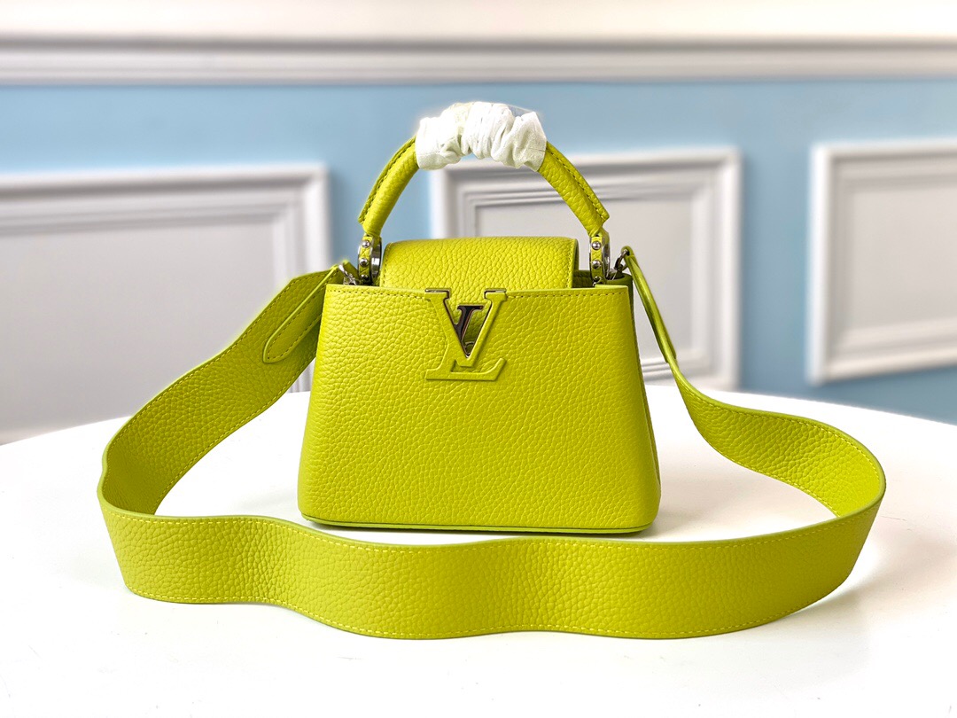 LOUIS VUITTON Capucines Mini. Original Quality Bag including gift box, literature, dust bag, authenticity card. Fashioned from vibrantly colored Taurillon leather, the Capucines Mini handbag pops. The fresh new colorway is perfectly complemented by the discreet metal handle rings. Like all Capucines, the Mini can be carried with the flap out for simple sophistication or tucked inside to feature the LV Initials. | CRIS&COCO Authentic Quality Designer Bag and Luxury Accessories