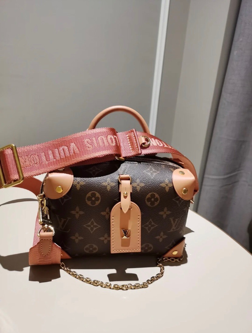 LOUIS VUITTON Petite Malle Souple. Original Quality Bag including gift box, care book, dust bag, authenticity card. The distinctive LV Petite Malle Souple is a soft handbag steeped in House history. The Monogram canvas, riveted leather corners, and leather name tag all evoke LOUIS VUITTON’s legacy as a trunk maker. A gold-color nautical chain and wide removable strap, with LOUIS VUITTON Malletier, embroidered on it, bring up-to-the-minute style. | CRIS AND COCO High Quality Bags and Luxury Accessories