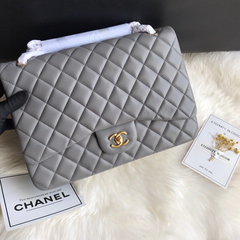 CHANEL Maxi Classic Handbag. Original Quality Bag including gift box, care book, dust bag, authenticity card. The Maxi Classic Double Flap bags are available in both grained calfskin and lambskin with silver/gold tone hardware. This classic handbag features a front flap with signature CC turn lock closure, half-moon back pocket. Also an adjustable interwoven silver/gold tone chain link and leather shoulder strap. | CRIS&COCO Authentic Quality Designer Bags and Luxury Accessories