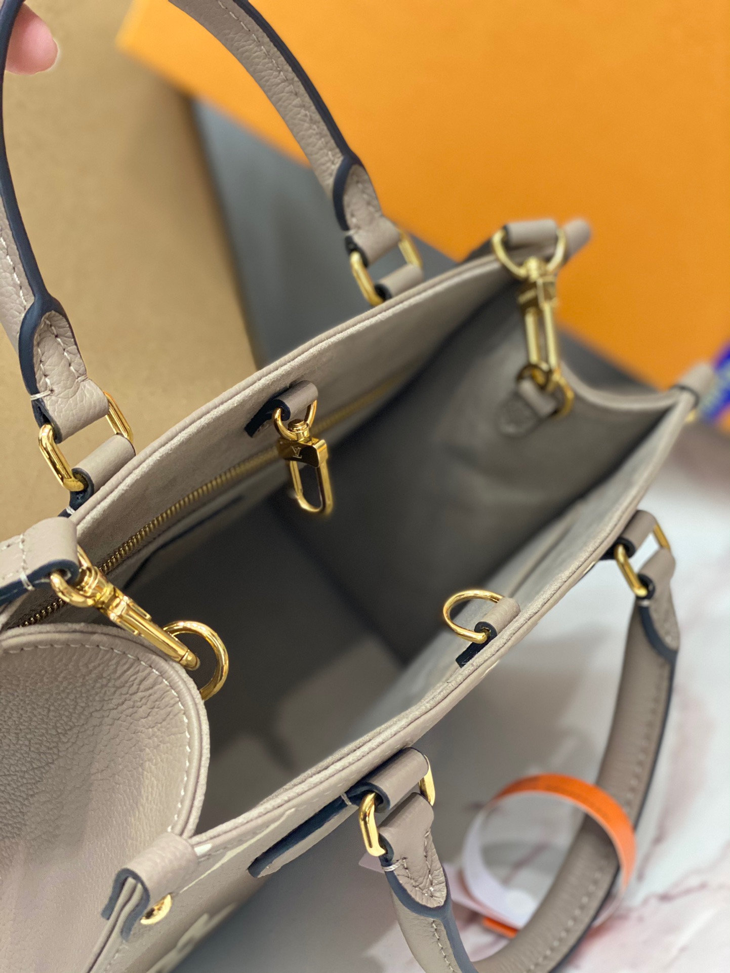 LOUIS VUITTON Onthego PM. Original Quality Bag including gift box, care book, dust bag, authenticity card. Inspired by Louis Vuitton’s famous Sac Plat from 1968, the Onthego PM tote is fashioned in Monogram Empreinte leather, embossed with a Giant Bicolor Monogram pattern. This smaller version of the original Onthego fits essentials such as an iPad Mini. Articulated top handles and an adjustable removable strap offer a variety of carry options. | CRIS&COCO Authentic Quality Designer Bags and Luxury Accessories