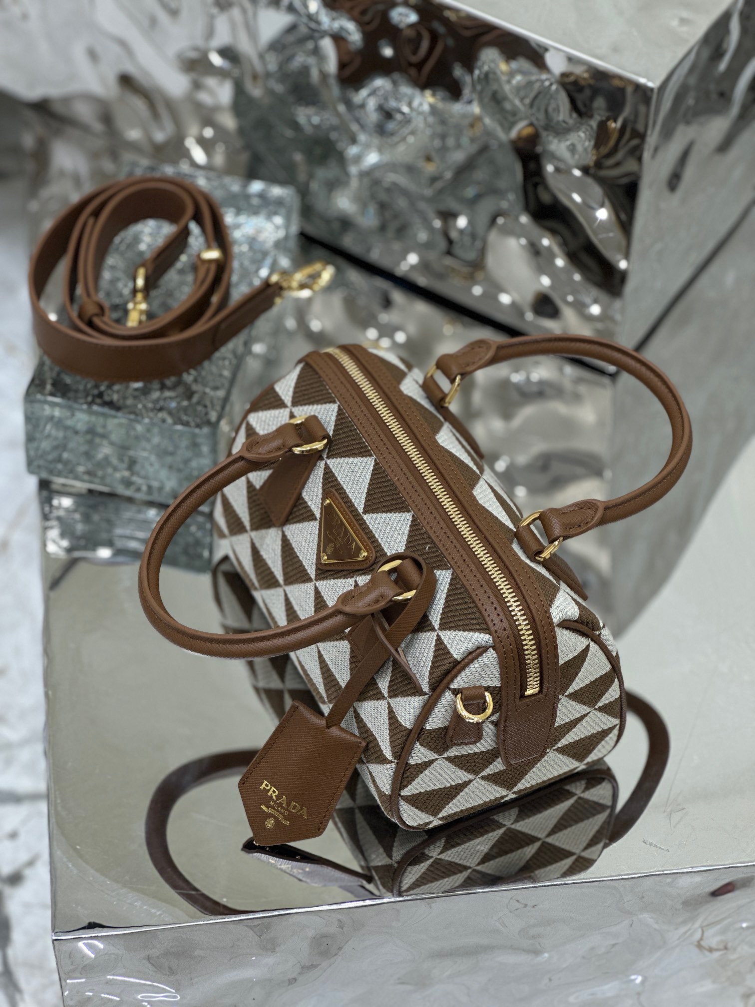 PRADA Symbole Embroidered Fabric Top-Handle Bag. Original Quality Bag including gift box, care book, dust bag, authenticity card.  Made of fabric with Saffiano handles, this top-handle bag combines a classic silhouette with modern, functional details. Here, the brand's iconic geometric design is transformed into a sophisticated yet modernist pattern that plays with contrasting colors and decorates this versatile bag. | CRIS&COCO Authentic Quality Designer Bags and Luxury Accessories