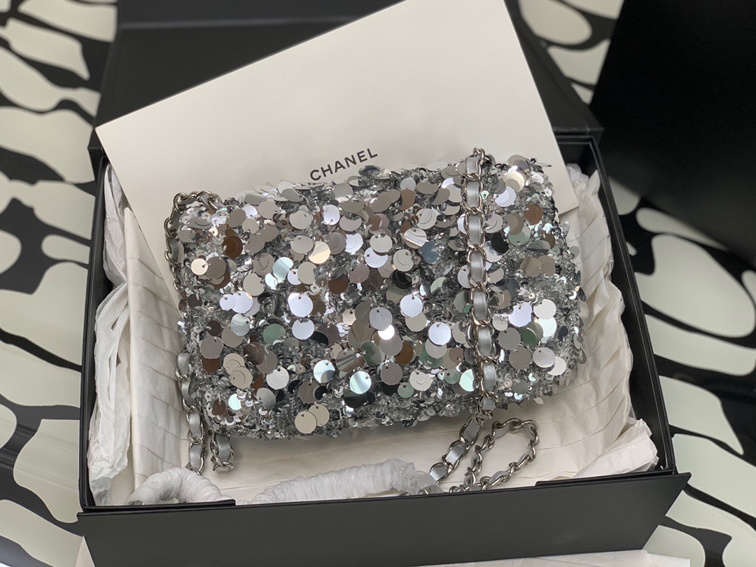 CHANEL Mini Flap Bag In Sequins.  Original Quality Bag including gift box, care book, dust bag, authenticity card. This small sleek flap bag is beautifully crafted of the layering of small and large sequins that create the entire surface of the bag. The elegant handbag features polished chain link leather threaded shoulder straps and a Chanel CC turn lock. This opens to a leather interior with room for your necessities for day or evening with the timeless style. | CRIS AND COCO Authentic Quality Luxury Accessories