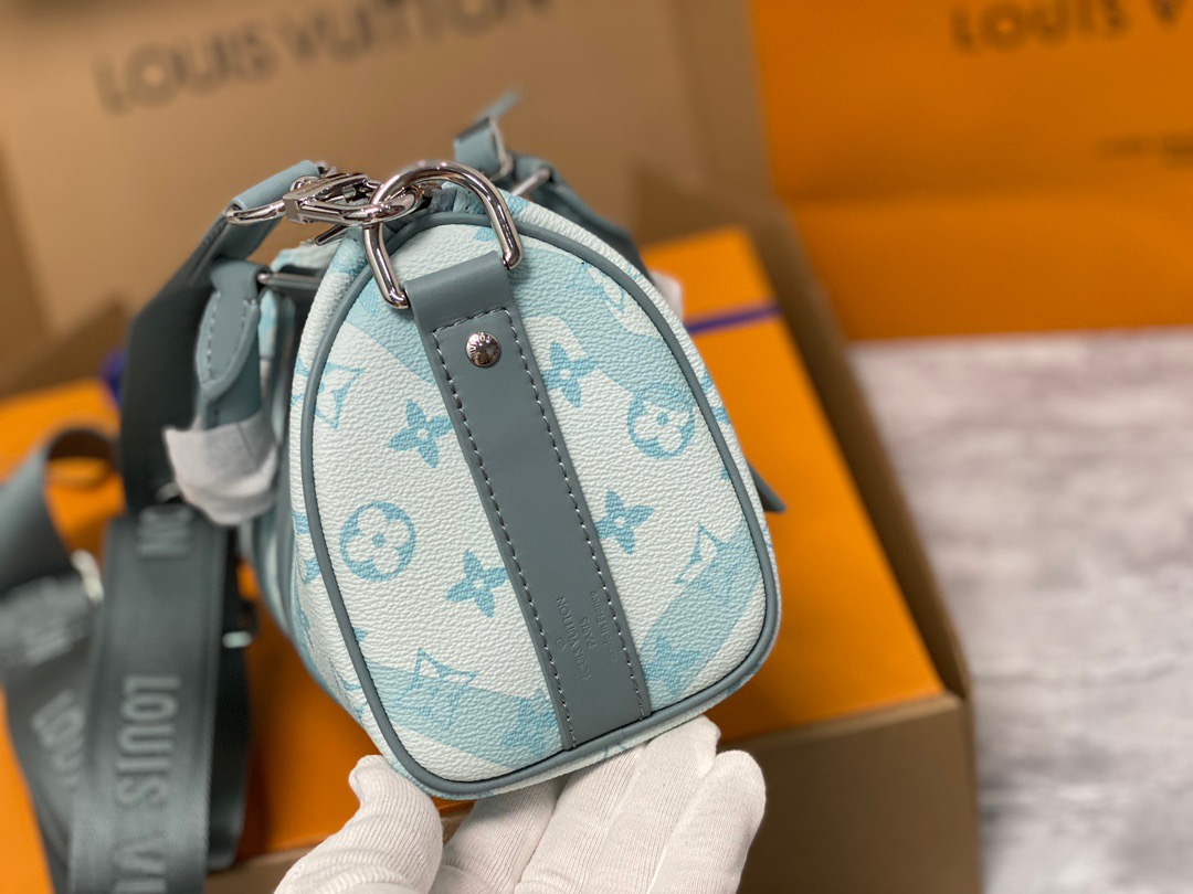 LOUIS VUITTON Keepall Bandoulière 25. Be immersed in style. The Keepall Bandoulière 25 is crafted from Monogram Aquagarden canvas, with LV and Monogram Flowers appearing to be immersed in drops of water. This effect is created using an imaginative inkjet technique. This compact bag includes the two lateral reinforcement bands and the leather name tag, both classic signature details of the Keepall.