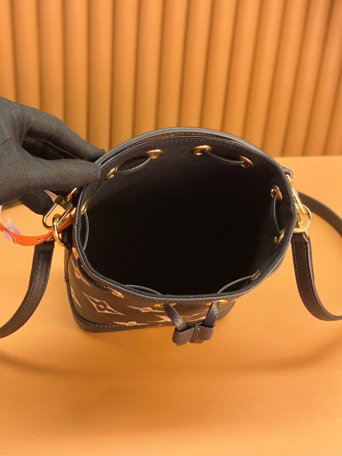 LOUIS VUITTON Nano Noé. Style meets functionality: the perfect companion for your everyday essentials. The Nano Noé in a bicolor design is made from Monogram Empreinte leather, showcasing the embossed Monogram pattern. This compact version of the iconic Noé bag adds a touch of elegance to your daily essentials. Along with a convenient drawstring closure, it also offers versatility with a detachable handle and an adjustable shoulder strap for various carrying choices. | CRIS&COCO Authentic Quality Designer Bags and Luxury Accessories