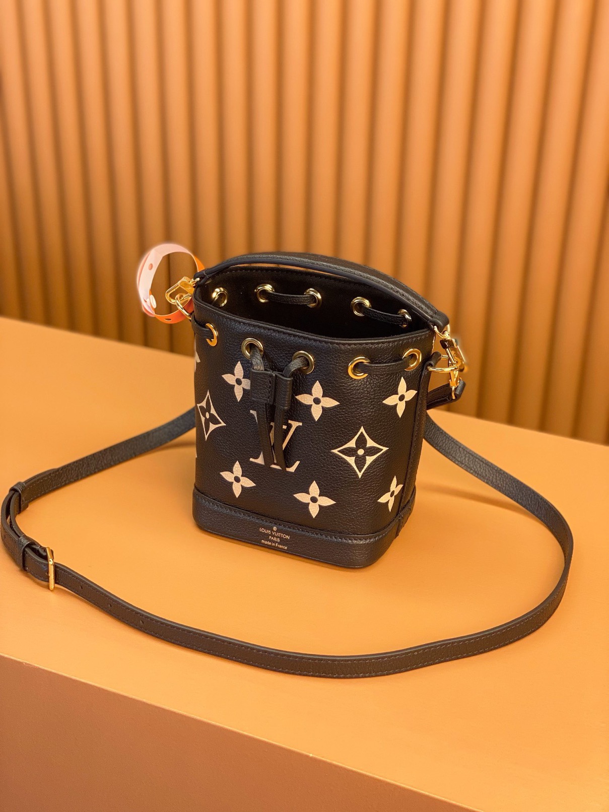 LOUIS VUITTON Nano Noé. Style meets functionality: the perfect companion for your everyday essentials. The Nano Noé in a bicolor design is made from Monogram Empreinte leather, showcasing the embossed Monogram pattern. This compact version of the iconic Noé bag adds a touch of elegance to your daily essentials. Along with a convenient drawstring closure, it also offers versatility with a detachable handle and an adjustable shoulder strap for various carrying choices. | CRIS&COCO Authentic Quality Designer Bags and Luxury Accessories