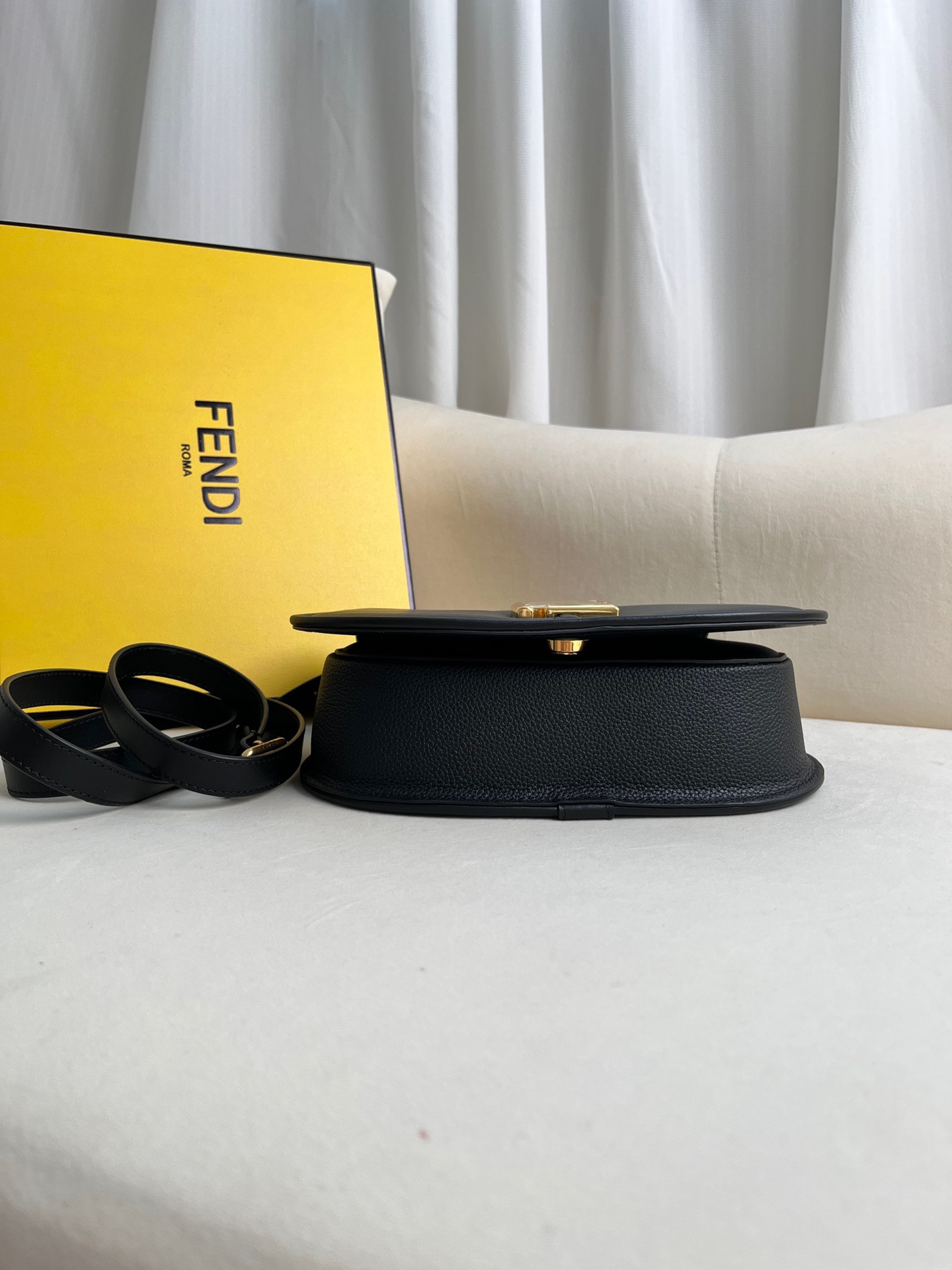 FENDI C’mon Medium. Timeless Elegance, Embodied in Leather. Elegantly designed, this medium-sized satchel bag boasts graceful, curved lines that exude femininity. Its elongated flap is adorned with a striking metal FF logo, adding a touch of sophistication to its overall charm. Crafted from supple leather with meticulously embossed edges and intricate details, this bag radiates a sense of refined luxury. The sides of the bag seamlessly blend with the overall design, crafted from the same tone-on-tone full-grain leather, ensuring a harmonious and visually pleasing aesthetic.