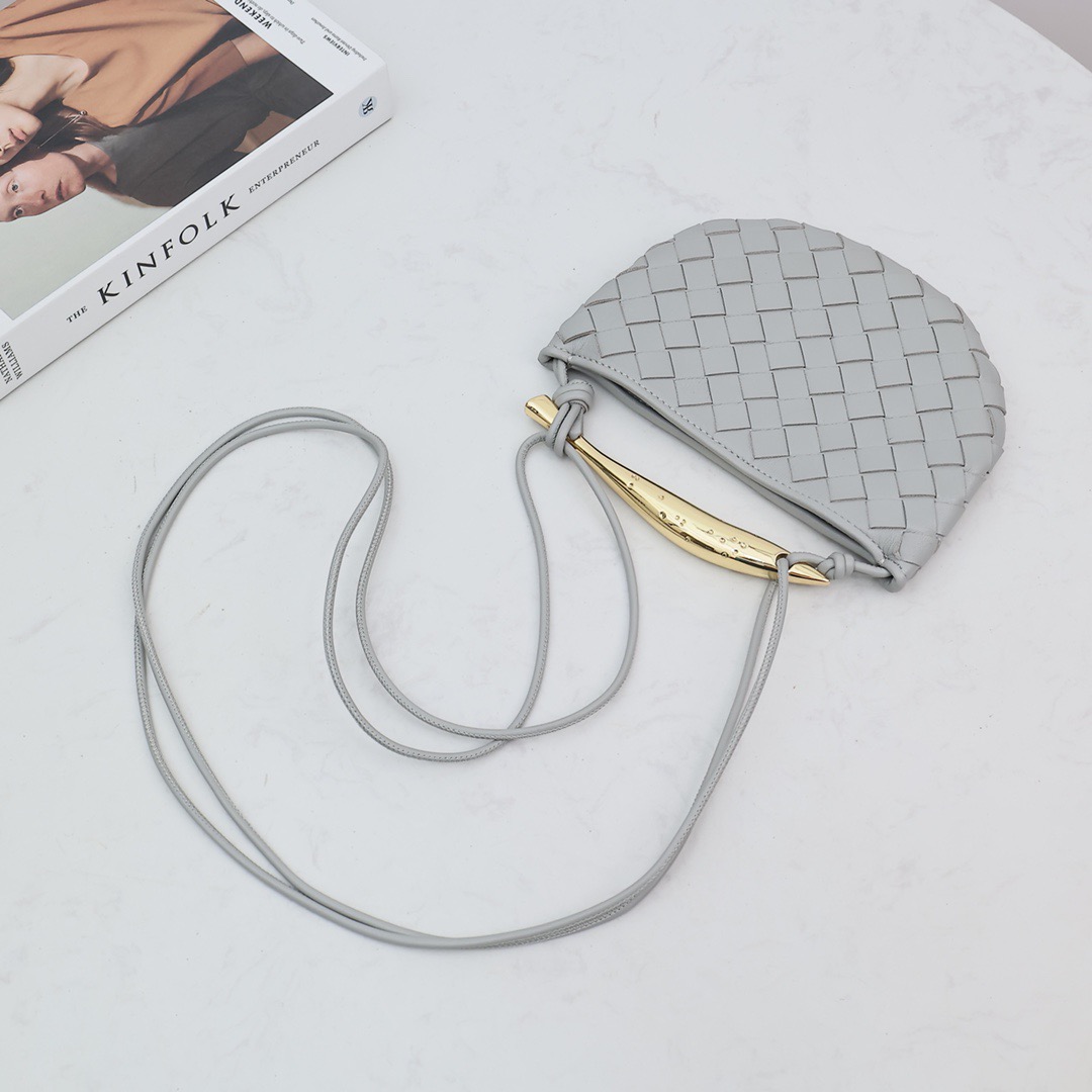 BOTTEGA VENETA Mini Sardine. Crafted to Perfection, Inspired by Nature: Your Timeless Companion for All Occasions. Bottega Veneta's masterful intrecciato weaving technique was originally crafted to ensure the enduring quality of leather goods. The Sardine Mini leather shoulder bag, meticulously fashioned from supple lamb leather, showcases a distinctive top handle reminiscent of a graceful fish. This versatile piece seamlessly transitions from day to night, making it the perfect, reliable companion to elegantly accommodate all your essentials.