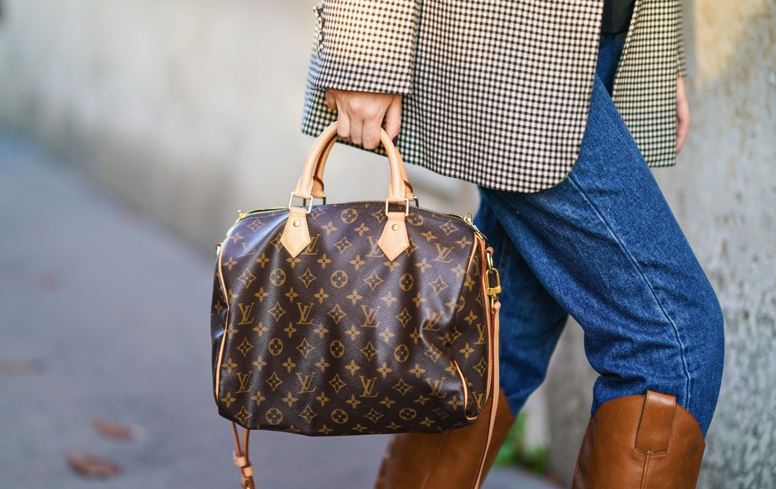 Woman with a LOUIS VUITTON Speedy bag. A woman carrying a LOUIS VUITTON Speedy bag while walking.