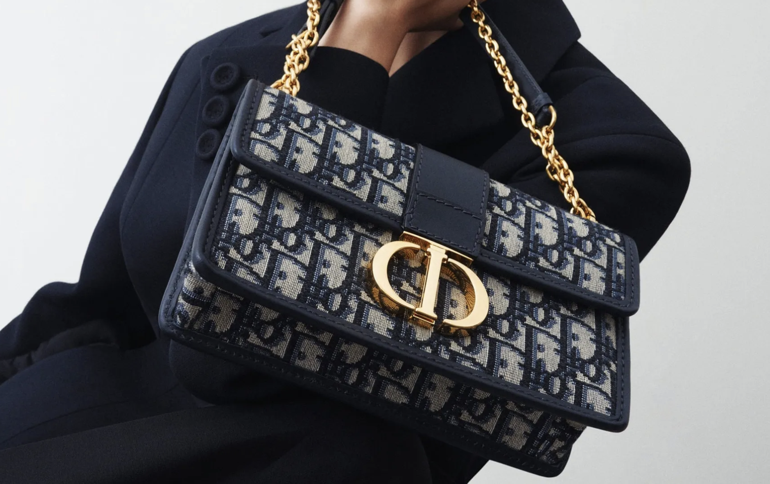 Woman confidently carrying a designer handbag.