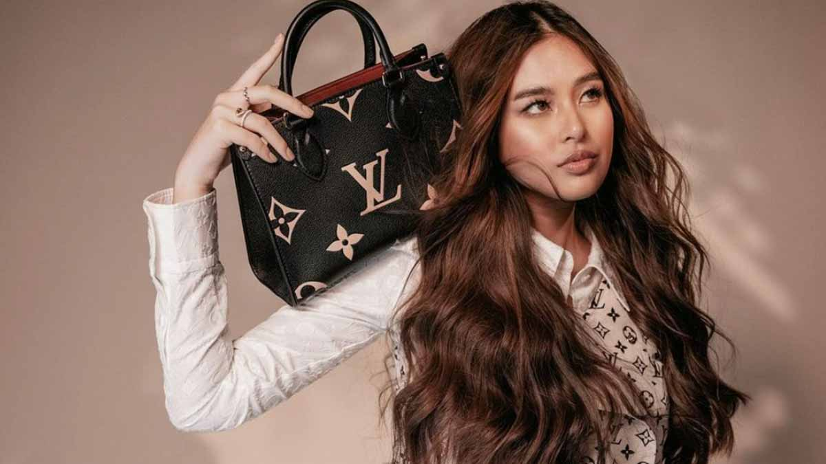 A sophisticated woman holding a designer-inspired handbag in front of a luxurious boutique.