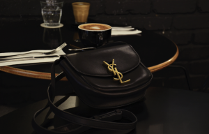 A chic SAINT LAURENT Kaia bag displayed elegantly on a modern marble table with gold accents.