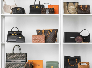 A collection of luxury bags from iconic brands like CHANEL, LOUIS VUITTON, and HERMÈS displayed elegantly on a vintage table.