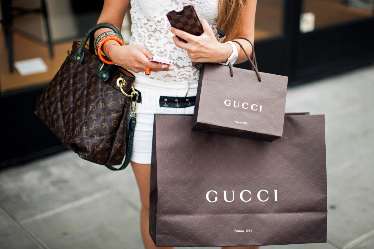 A shopper holding a luxury handbag with an eye-watering total. A shopper holding a luxury handbag with an eye-watering total.