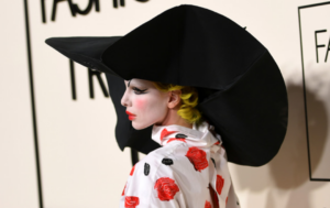 Julia Fox in clowncore makeup with a luxury-style bag