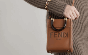 Trendy woman carrying a FENDI MINI SUNSHINE SHOPPER replica bag on a cobblestone street.