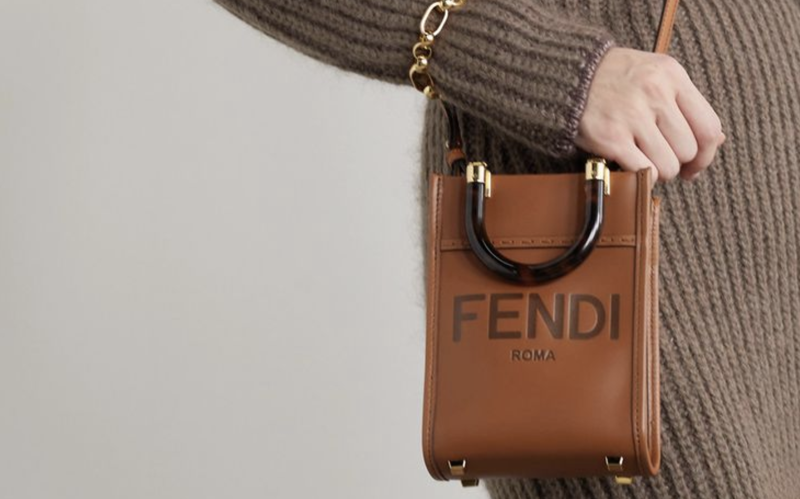 Trendy woman carrying a FENDI MINI SUNSHINE SHOPPER replica bag on a cobblestone street. Trendy woman carrying a FENDI MINI SUNSHINE SHOPPER replica bag on a cobblestone street.