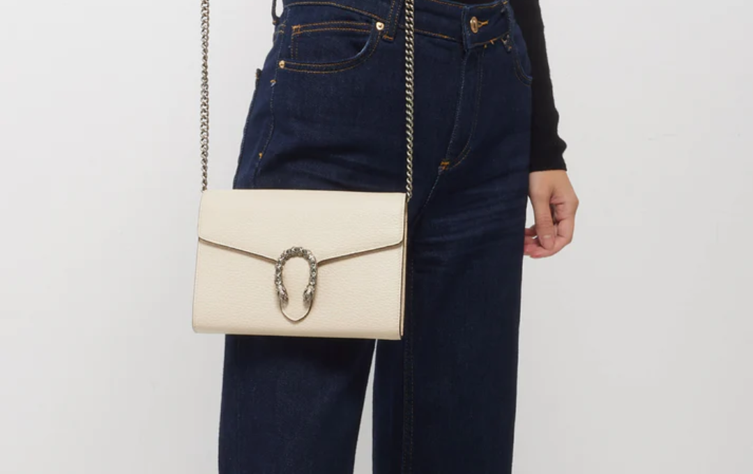 A crisp white GUCCI Wallet With Chain placed on a glossy marble table. A crisp white GUCCI Wallet With Chain placed on a glossy marble table.