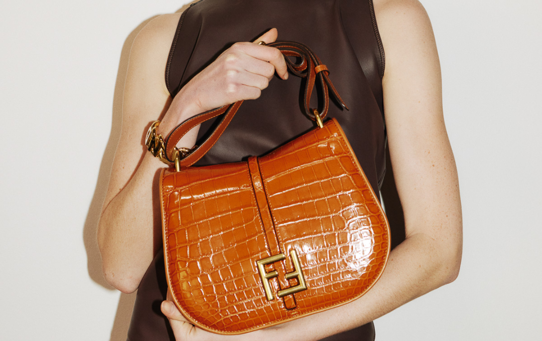 A fashionable woman flaunting a FENDI C'MON MINI replica bag with city skyscrapers in the background.