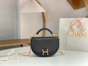 Marcie Chain Flap Bag. Authentic quality luxury bag crafted in genuine leather comes with authenticity card, dust bag and gift bag. Elevating Iconic Elegance: Marcie Line Redefined. Experience a fresh take on *loé's iconic Marcie line with this exquisite chain flap bag, meticulously crafted from a captivating blend of nappa lambskin, grained calfskin, and sumptuous suede. The line's signature hardware undergoes a graceful transformation, now adorned with *loé's engraved jewelry hallmark, adorning the flap with sophistication. An intricately hand-braided top handle pays homage to another hallmark Marcie feature, while a gracefully extended chain strap adds a refined touch. Whether you choose to drape it over your shoulder or wear it cross-body during the day, or opt to detach the strap and carry it by hand for a sophisticated evening ensemble, this flap bag is a versatile masterpiece. *loé's Marcie bag line effortlessly melds a feminine aesthetic with the free-spirited vibe of the '70s. An equestrian-inspired allure takes center stage, elevated by the allure of gleaming gold-toned hardware, resulting in a distinctly feminine yet timelessly chic look.