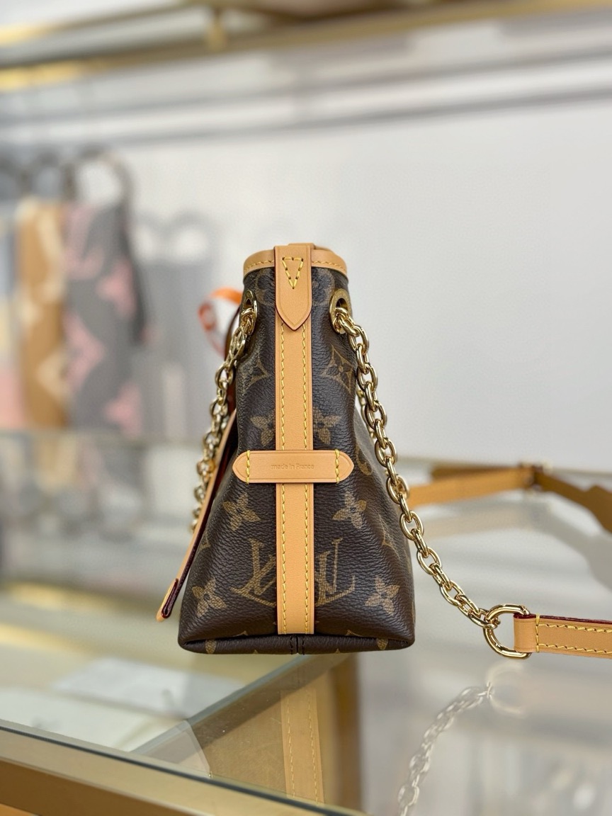 CarryAll BB. Authentic quality luxury bag crafted in genuine leather comes with authenticity card, dust bag and gift bag. Effortless Elegance, Day to Night – The CarryAll BB Reimagined. The iconic CarryAll BB returns this season with a stylish twist, perfect for transitioning from day to evening. Expertly crafted from the House’s signature Monogram canvas, it’s elevated with a gleaming gold-toned chain adorned with Monogram Flowers. Thoughtful details like the contrasting leather name tag and matching lace closure add a refined touch. Inside, a zipped pocket offers a convenient spot to keep your everyday essentials—like a credit card—close at hand.