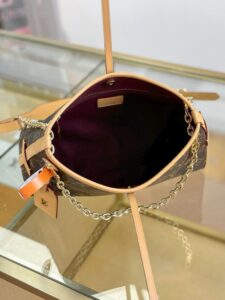 CarryAll BB. Authentic quality luxury bag crafted in genuine leather comes with authenticity card, dust bag and gift bag. Effortless Elegance, Day to Night – The CarryAll BB Reimagined. The iconic CarryAll BB returns this season with a stylish twist, perfect for transitioning from day to evening. Expertly crafted from the House’s signature Monogram canvas, it’s elevated with a gleaming gold-toned chain adorned with Monogram Flowers. Thoughtful details like the contrasting leather name tag and matching lace closure add a refined touch. Inside, a zipped pocket offers a convenient spot to keep your everyday essentials—like a credit card—close at hand.