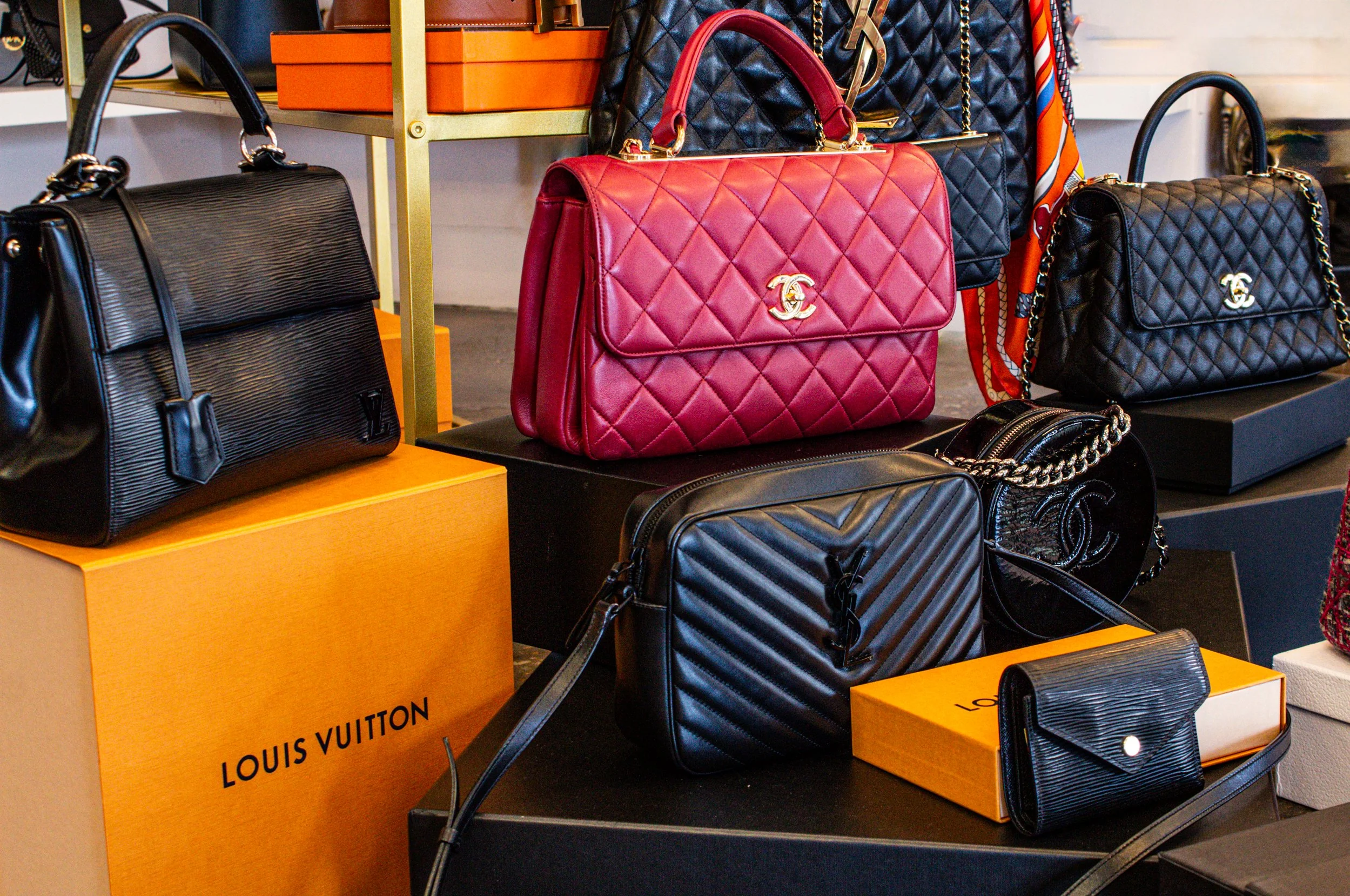 Conceptual image of a woman walking past a luxury boutique, faceless and carrying a minimalist designer bag