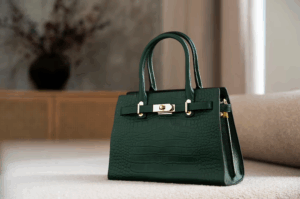 A luxurious Hermès handbag in rich emerald green leather, featuring the brand’s signature hardware and elegant stitching, displayed against a minimalist background.