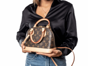 Woman holding a structured ALMA BB 2WAY BAG at a garden wedding