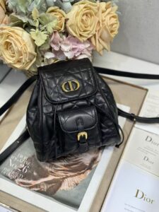 Small Caro Backpack. Authentic quality luxury bag crafted in genuine leather comes with authenticity card, dust bag and gift bag. Elegance Meets Effortless Edge. Elevate your everyday with the Small Caro Backpack — a flawless blend of modern femininity and iconic House craftsmanship. Luxuriously crafted in lambskin, its supple silhouette is enhanced by bold Macrocannage topstitching that whispers timeless *ior style. The antique gold-finish ‘CD’ clasp opens to a drawstring main compartment, perfectly balancing beauty and practicality. A discreet flap pocket keeps your daily essentials close at hand, while the top handle and adjustable leather straps offer versatile, all-day comfort. Whether slung over your shoulder or carried by hand, this petite powerhouse delivers Parisian polish in every step. - CRIS&COCO Small Caro Backpack. Authentic quality luxury bag crafted in genuine leather comes with authenticity card, dust bag and gift bag. Elegance Meets Effortless Edge. Elevate your everyday with the Small Caro Backpack — a flawless blend of modern femininity and iconic House craftsmanship. Luxuriously crafted in lambskin, its supple silhouette is enhanced by bold Macrocannage topstitching that whispers timeless *ior style. The antique gold-finish ‘CD’ clasp opens to a drawstring main compartment, perfectly balancing beauty and practicality. A discreet flap pocket keeps your daily essentials close at hand, while the top handle and adjustable leather straps offer versatile, all-day comfort. Whether slung over your shoulder or carried by hand, this petite powerhouse delivers Parisian polish in every step.