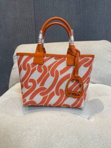 Steeple 25 Bag. Authentic quality luxury bag crafted in genuine leather comes with authenticity card, dust bag and gift bag. Where art meets heritage. The *rmès Steeple Bag is a charming fusion of heritage and artistry, crafted from a blend of canvas and Swift leather. Its design pays tribute to *rmès’ equestrian roots with whip-shaped handles and a stirrup-inspired charm, adding a playful yet sophisticated touch. Lightweight yet spacious, the Steeple is ideal for daily use. Whether you opt for a vibrant motif or a sleek, single-color design, this bag stands out as an artistic expression of luxury that seamlessly integrates into a modern lifestyle. Praised for its unique aesthetic and accessibility within the *rmès lineup, the Steeple Bag is adored by fashion enthusiasts who appreciate its colorful palette and bold personality. While it’s best suited for those who enjoy the texture and look of canvas, it remains a versatile statement piece that captures the spirit of everyday elegance.