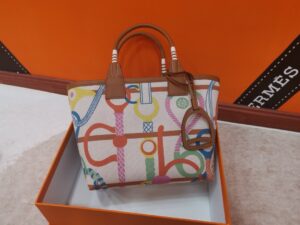 Steeple 25 Bag. Authentic quality luxury bag crafted in genuine leather comes with authenticity card, dust bag and gift bag. Where art meets heritage. The *rmès Steeple Bag is a charming fusion of heritage and artistry, crafted from a blend of canvas and Swift leather. Its design pays tribute to *rmès’ equestrian roots with whip-shaped handles and a stirrup-inspired charm, adding a playful yet sophisticated touch. Lightweight yet spacious, the Steeple is ideal for daily use. Whether you opt for a vibrant motif or a sleek, single-color design, this bag stands out as an artistic expression of luxury that seamlessly integrates into a modern lifestyle. Praised for its unique aesthetic and accessibility within the *rmès lineup, the Steeple Bag is adored by fashion enthusiasts who appreciate its colorful palette and bold personality. While it’s best suited for those who enjoy the texture and look of canvas, it remains a versatile statement piece that captures the spirit of everyday elegance. - CRIS&COCO Steeple 25 Bag. Authentic quality luxury bag crafted in genuine leather comes with authenticity card, dust bag and gift bag. Where art meets heritage. The *rmès Steeple Bag is a charming fusion of heritage and artistry, crafted from a blend of canvas and Swift leather. Its design pays tribute to *rmès’ equestrian roots with whip-shaped handles and a stirrup-inspired charm, adding a playful yet sophisticated touch. Lightweight yet spacious, the Steeple is ideal for daily use. Whether you opt for a vibrant motif or a sleek, single-color design, this bag stands out as an artistic expression of luxury that seamlessly integrates into a modern lifestyle. Praised for its unique aesthetic and accessibility within the *rmès lineup, the Steeple Bag is adored by fashion enthusiasts who appreciate its colorful palette and bold personality. While it’s best suited for those who enjoy the texture and look of canvas, it remains a versatile statement piece that captures the spirit of everyday elegance.