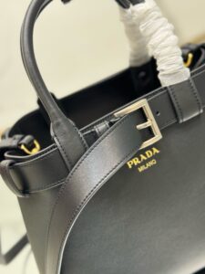 Buckle Small Leather Handbag. Authentic quality luxury bag crafted in genuine leather comes with authenticity card, dust bag and gift bag. Sophistication Meets Utility. Sleek, structured, and undeniably Pr*da — the Buckle Small Leather Handbag captures the brand’s signature balance of minimalist elegance and refined detail. Crafted in smooth leather with a buttery-soft nappa interior, this compact piece is a masterclass in functional luxury. A standout feature? Its interchangeable belt strap, adding a bold, modern twist to the timeless silhouette. Whether you're heading to a meeting or a soirée, this bag adapts seamlessly to your mood and moment. Finished with the embossed iconic logo, it’s a quiet statement of taste and distinction. A versatile companion for the woman who appreciates precision, polish, and just the right touch of edge. - CRIS&COCO Buckle Small Leather Handbag. Authentic quality luxury bag crafted in genuine leather comes with authenticity card, dust bag and gift bag. Sophistication Meets Utility. Sleek, structured, and undeniably Pr*da — the Buckle Small Leather Handbag captures the brand’s signature balance of minimalist elegance and refined detail. Crafted in smooth leather with a buttery-soft nappa interior, this compact piece is a masterclass in functional luxury. A standout feature? Its interchangeable belt strap, adding a bold, modern twist to the timeless silhouette. Whether you're heading to a meeting or a soirée, this bag adapts seamlessly to your mood and moment. Finished with the embossed iconic logo, it’s a quiet statement of taste and distinction. A versatile companion for the woman who appreciates precision, polish, and just the right touch of edge.