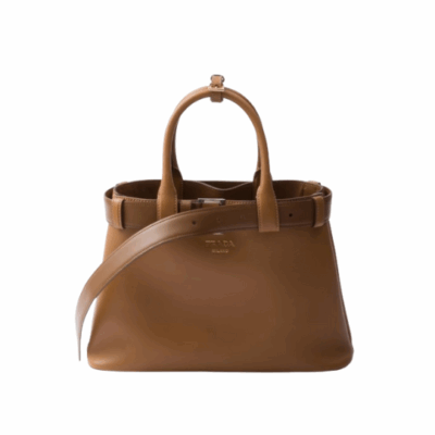 Buckle Small Leather Handbag. Authentic quality luxury bag crafted in genuine leather comes with authenticity card, dust bag and gift bag. Sophistication Meets Utility. Sleek, structured, and undeniably Pr*da — the Buckle Small Leather Handbag captures the brand’s signature balance of minimalist elegance and refined detail. Crafted in smooth leather with a buttery-soft nappa interior, this compact piece is a masterclass in functional luxury. A standout feature? Its interchangeable belt strap, adding a bold, modern twist to the timeless silhouette. Whether you're heading to a meeting or a soirée, this bag adapts seamlessly to your mood and moment. Finished with the embossed iconic logo, it’s a quiet statement of taste and distinction. A versatile companion for the woman who appreciates precision, polish, and just the right touch of edge.