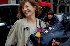Young woman taking a mirror selfie with a replica BIRKIN