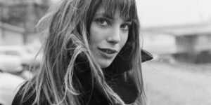Jane Birkin walking down a cobblestone street in Paris in the 1970s