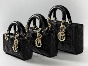 Woman confidently carrying an orange replica BIRKIN bag while walking through New York City