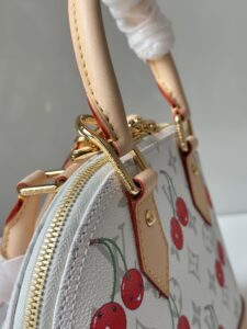 LV x TM Alma BB. Authentic quality luxury bag crafted in genuine leather comes with authenticity card, dust bag and gift bag. A Joyful Icon Reimagined. Playful, artistic, and instantly iconic—the Alma BB returns in a joyful re-edition as part of the celebrated LV x TM collection. This petite masterpiece blends the timeless Art Deco-inspired silhouette with Takashi Murakami’s signature whimsy, splashing the House’s Monogram canvas with bold, cherry-bright motifs. Crafted with natural leather accents and finished with polished gold-tone hardware, it features structured Toron top handles and a charming bow-shaped keybell that adds just the right amount of flirt. Compact yet attention-commanding, the Alma BB is a true collectible—full of joy, color, and unmistakable LV heritage. Carry art. Wear happiness. Make a statement. - CRIS&COCO LV x TM Alma BB. Authentic quality luxury bag crafted in genuine leather comes with authenticity card, dust bag and gift bag. A Joyful Icon Reimagined. Playful, artistic, and instantly iconic—the Alma BB returns in a joyful re-edition as part of the celebrated LV x TM collection. This petite masterpiece blends the timeless Art Deco-inspired silhouette with Takashi Murakami’s signature whimsy, splashing the House’s Monogram canvas with bold, cherry-bright motifs. Crafted with natural leather accents and finished with polished gold-tone hardware, it features structured Toron top handles and a charming bow-shaped keybell that adds just the right amount of flirt. Compact yet attention-commanding, the Alma BB is a true collectible—full of joy, color, and unmistakable LV heritage. Carry art. Wear happiness. Make a statement.