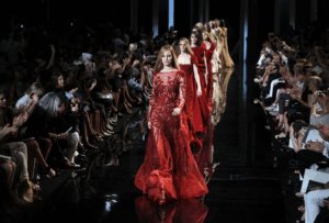 Luxury on the runway, stitched in silence. The true cost walks behind the curtain.