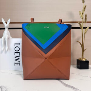 Medium Puzzle Fold Tote.  Authentic quality luxury bag crafted in genuine leather comes with authenticity card, dust bag and gift bag. Modern art meets effortless luxury. This exceptional piece reimagines the iconic Puzzle Fold silhouette with a lightweight geometric structure that folds completely flat, making it the ultimate travel companion. Crafted in supple nappa calfskin, the tote features exquisite leather marquetry squares inspired by Josef Albers’s celebrated Homage to the Square series. Each panel reflects precision, balance, and *OEWE’s unmatched craftsmanship, transforming a functional tote into a wearable work of art. Part of the exclusive *OEWE x Albers collection, this medium Puzzle Fold tote blends practicality with cultural sophistication, offering spacious elegance for everyday moments, weekend escapes, and artful adventures. A collectible masterpiece—crafted for the modern collector.