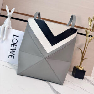 Medium Puzzle Fold Tote.  Authentic quality luxury bag crafted in genuine leather comes with authenticity card, dust bag and gift bag. Modern art meets effortless luxury. This exceptional piece reimagines the iconic Puzzle Fold silhouette with a lightweight geometric structure that folds completely flat, making it the ultimate travel companion. Crafted in supple nappa calfskin, the tote features exquisite leather marquetry squares inspired by Josef Albers’s celebrated Homage to the Square series. Each panel reflects precision, balance, and *OEWE’s unmatched craftsmanship, transforming a functional tote into a wearable work of art. Part of the exclusive *OEWE x Albers collection, this medium Puzzle Fold tote blends practicality with cultural sophistication, offering spacious elegance for everyday moments, weekend escapes, and artful adventures. A collectible masterpiece—crafted for the modern collector.