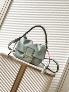 Small Mamma Baguette. Authentic quality luxury bag crafted in genuine leather comes with authenticity card, dust bag and gift bag. A Soft Revival of an Icon. Born in the late ’90s as the effortlessly chic “big sister” to the original, the Mamma Baguette returns for Spring/Summer 2025 with a modern, deconstructed allure. Reimagined in dreamy nappa leather, it blends nostalgia with a fresh, fluid silhouette that feels both relaxed and refined. An oversized FF clasp, accented with a tonal leather insert, anchors the design with signature *ENDI attitude. Inside, a generously sized suede-lined compartment with a drawstring closure and ties offers both luxury and practicality. Finished with gold-tone hardware and complete with detachable handle and shoulder strap, it transitions seamlessly from hand-held elegance to crossbody ease. Soft, iconic, and undeniably modern—the Mamma Baguette is back, and better than ever.
