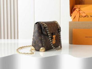Trunkie. Authentic quality luxury bag crafted in genuine leather comes with authenticity card, dust bag and gift bag. Heritage, Reimagined for Today. A bold tribute to the House’s storied past, the Trunkie brings the spirit of vintage travel into a sleek, modern silhouette. Crafted in iconic Monogram canvas and adorned with 38 gold-toned rivets, it echoes the timeless charm of classic LV trunks. Metallic corners and the signature S-lock closure elevate its structured design, while the sliding chain offers versatile styling—from shoulder to crossbody with effortless ease. Inside, a thoughtfully sized interior with a zipped pocket keeps your essentials perfectly organized. Where history meets modern sophistication, the Trunkie is more than a bag—it’s a statement of enduring luxury.