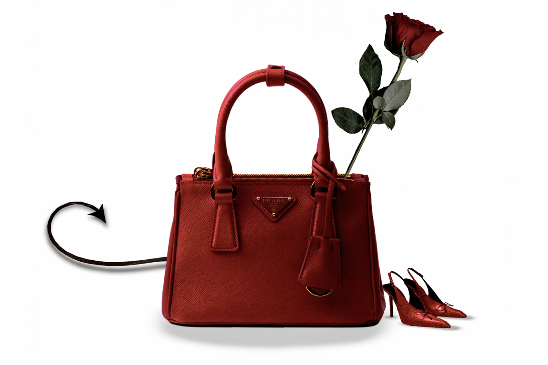 Home 3 Red designer handbag with a rose tucked through the handle and red high heels beside it on a white background