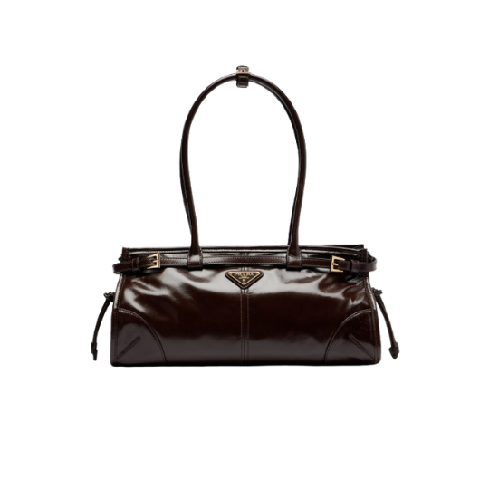 Bonnie Medium. Authentic quality luxury bag crafted in genuine leather comes with authenticity card, dust bag and gift bag. Modern Elegance with an Iconic Edge. The PR*DA Bonnie Medium Shoulder Bag is a sophisticated expression of contemporary Italian luxury. Crafted from glossy leather, its sleek elongated silhouette creates a refined, fashion-forward look that transitions effortlessly from day to night. Distinctive buckle detailing and the iconic enamel triangle logo celebrate PR*DA's rich heritage while embracing a modern, minimalist aesthetic. Thoughtfully designed with clean lines and impeccable craftsmanship, the Bonnie is both striking and effortlessly wearable. Perfectly sized for your everyday essentials, this versatile shoulder bag complements everything from tailored ensembles to casual weekend looks. Elegant, timeless, and unmistakably PR*DA, the Bonnie Medium is a statement piece designed for those who appreciate understated luxury with a contemporary twist.